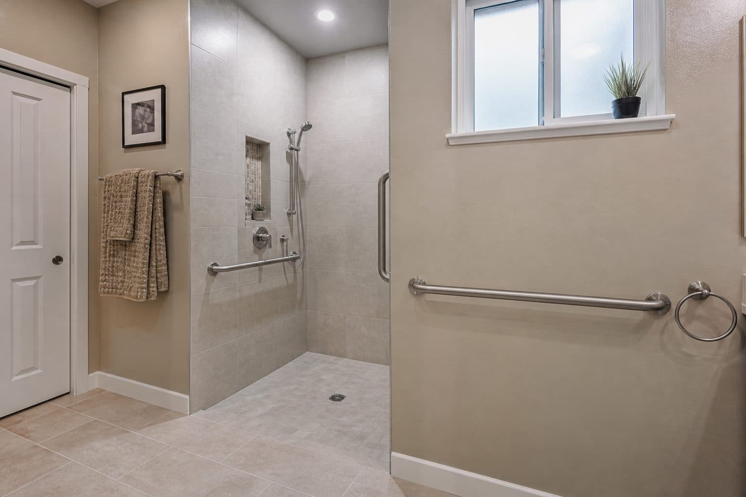 Residential roll-in shower with no curb, grab bars on blocking, and clear floor space.