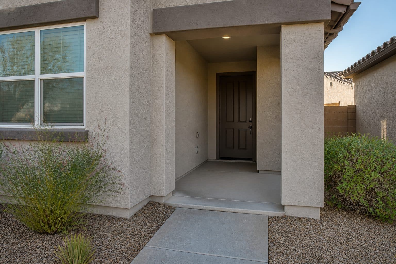 Zero-step front door with a covered landing and a low beveled threshold.