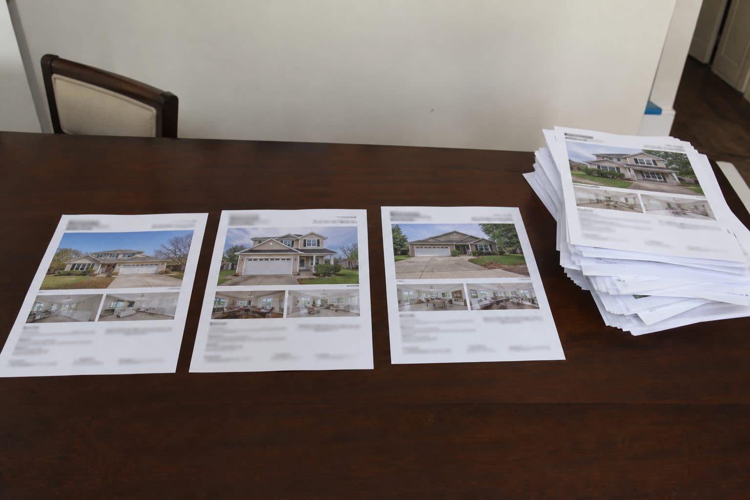 Three listing printouts side by side; a larger pile of rejected sheets set aside.